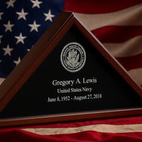 Memorial plaque for Gregory A. Lewis with U.S. Navy emblem and American flag in background